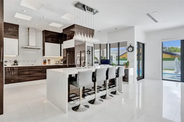 a kitchen with stainless steel appliances kitchen island granite countertop a stove a sink and a refrigerator