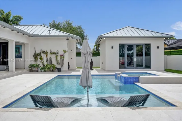 a view of a house with potted plants and a table and chairs