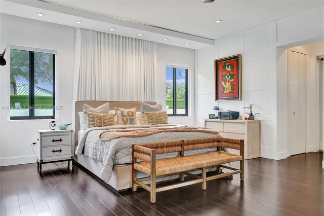 a bedroom with a bed wooden floor and window
