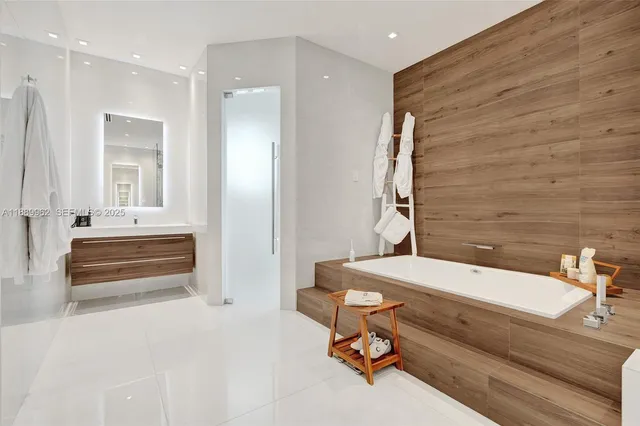 a bathroom with a tub sink and mirror