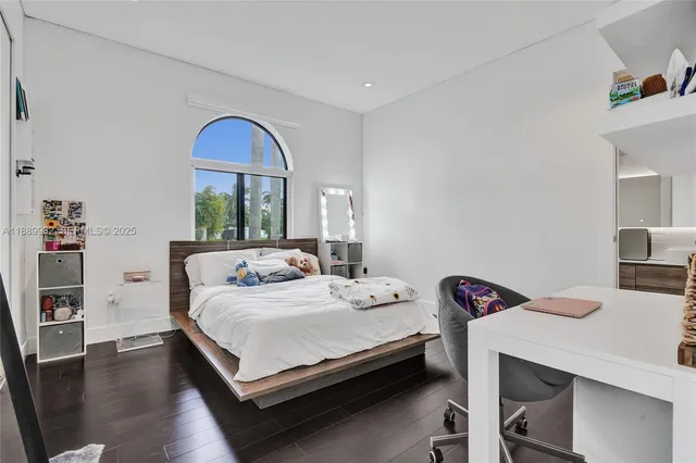 a spacious bedroom with a bed a table and a large mirror