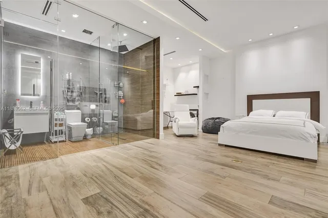 a spacious bathroom with a glass shower door and a toilet