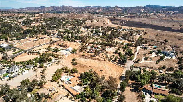 an aerial view of a residential houses with yard