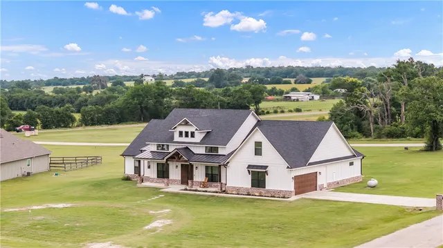 a view of a white house with a swimming pool and a yard