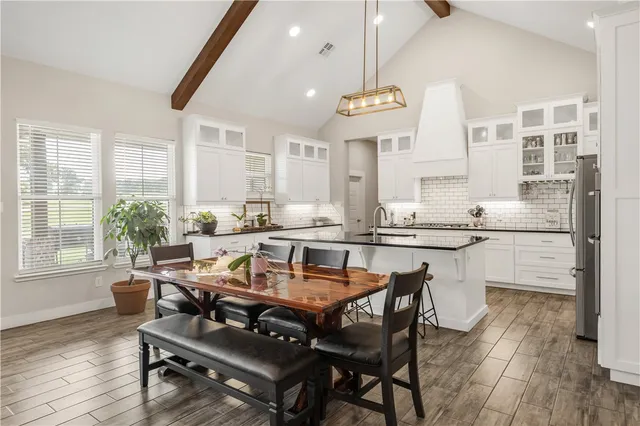 a dining room with wooden floor and stainless steel appliances