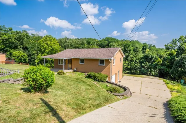 a view of a house with a yard and potted plants