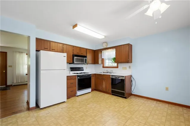 a kitchen with a refrigerator a stove top oven a sink and dishwasher
