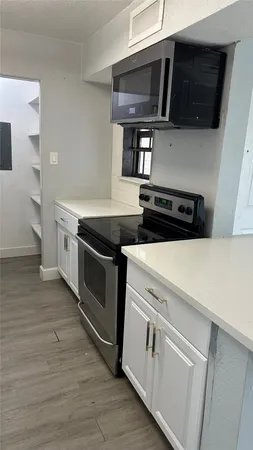 a kitchen with stainless steel appliances a stove microwave and sink