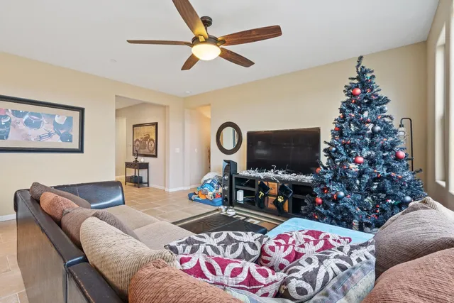 a living room with furniture a flat screen tv and a large window