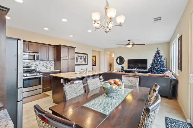 a kitchen with granite countertop kitchen island stainless steel appliances a sink stove and refrigerator