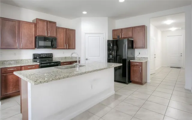 a kitchen with stainless steel appliances granite countertop a refrigerator sink and cabinets