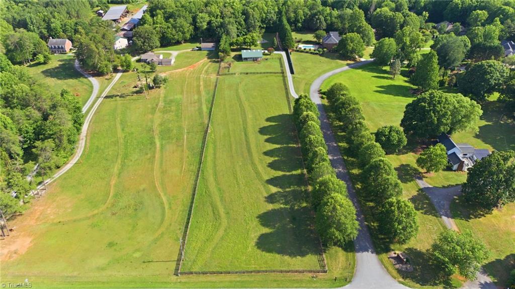 8861 Boylston Road Colfax, NC 27235 - Photo 2 of 50 From above, the property's unique layout comes into focus—5.53 private acres with open pasture, established equestrian amenities, and a home thoughtfully positioned for privacy.