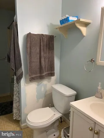 a white toilet sitting next to a bathroom sink and a mirror