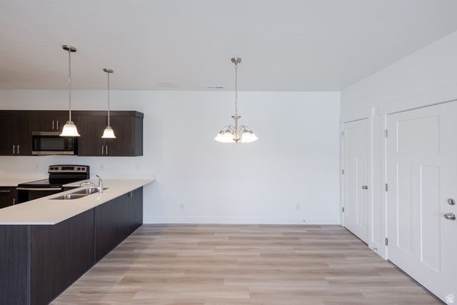675 West 4500th South, Unit P201 Mapleton, UT 84664 - Photo 13 of 16 Modern kitchen area featuring dark wood-finish cabinetry, light-toned countertops, and stainless steel appliances