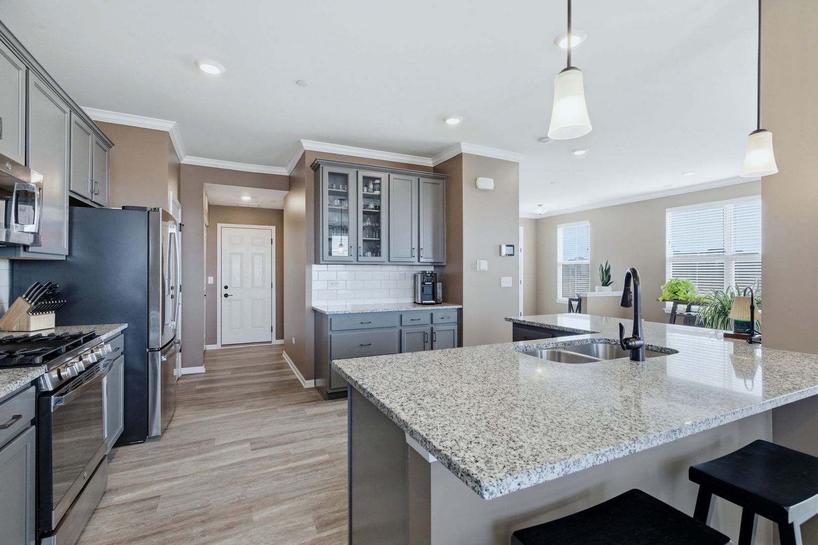 16436 Wheatgrass Street Lockport, IL 60441 - Photo 8 of 23 a kitchen with granite countertop kitchen island stainless steel appliances a sink stove and refrigerator
