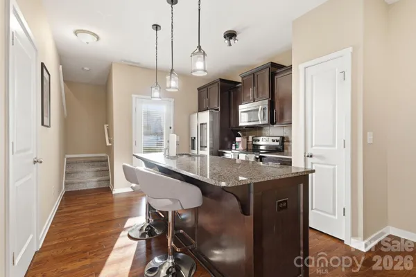 a kitchen with stainless steel appliances granite countertop a sink stove and refrigerator