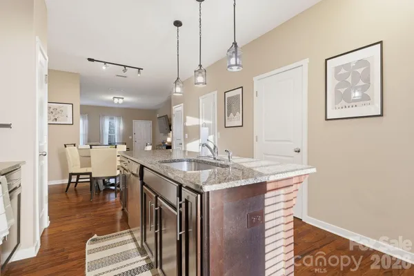 a hall with kitchen island a stove a table and chairs