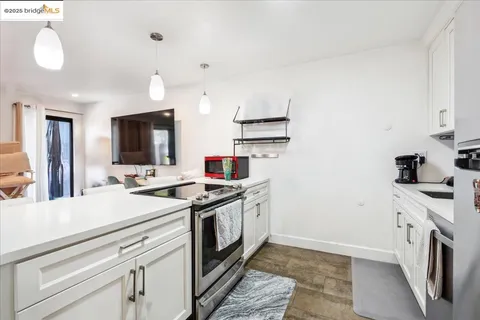 a kitchen with a stove and white cabinets