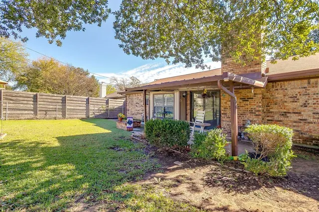 a view of a house with backyard and sitting area