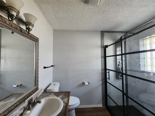 a bathroom with a sink mirror vanity and toilet