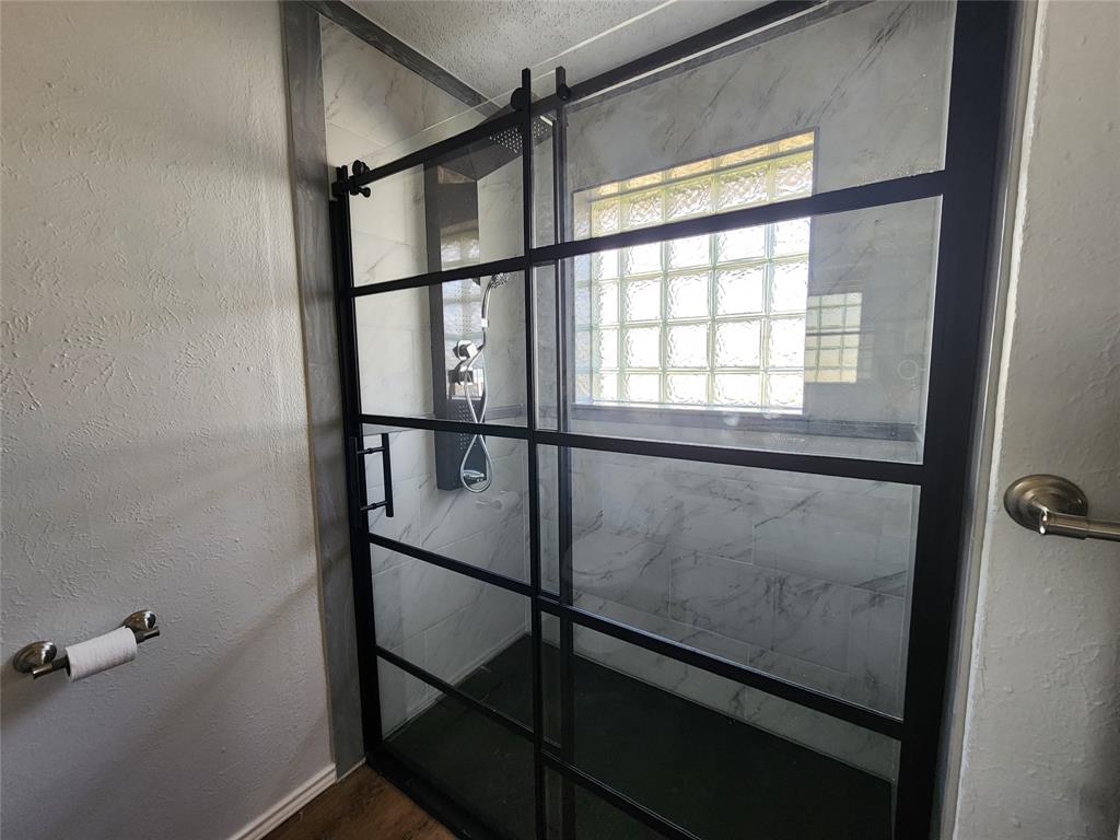 803 10th Street Princeton, TX 75407 - Photo 10 of 12 a bathroom with a glass shower door