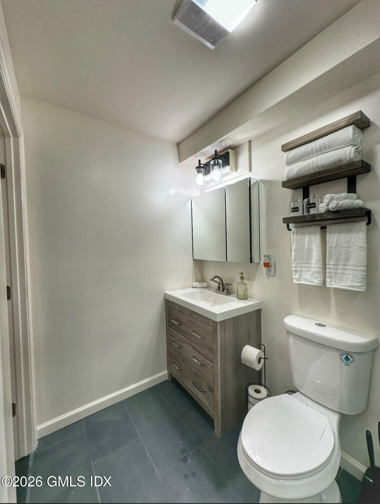 37 Gerry Street Greenwich, CT 06830 - Photo 13 of 14 a bathroom with a granite countertop toilet sink and mirror