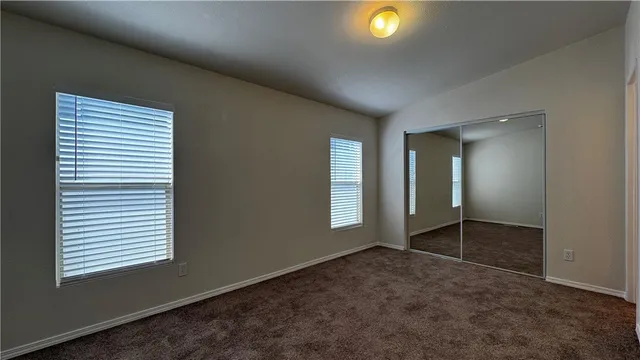 an empty room with windows and closet