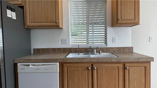 a kitchen with granite countertop a sink and a white cabinets
