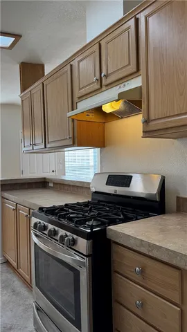 a kitchen with granite countertop cabinets stainless steel appliances and a sink