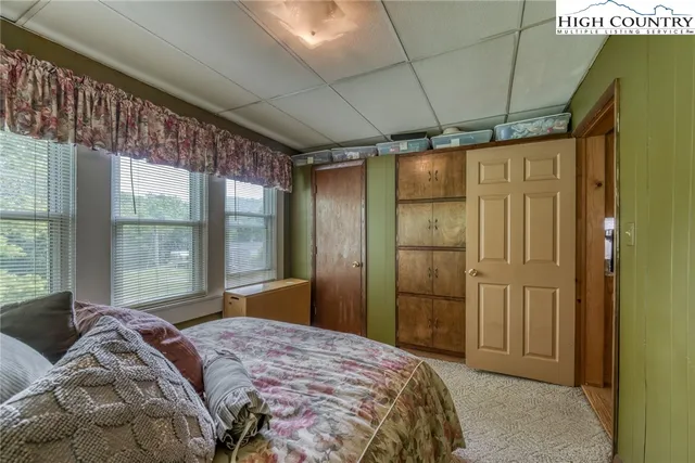 a bedroom with a bed and large window