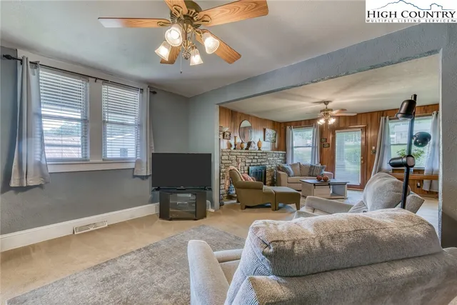 a living room with furniture a chandelier and a flat screen tv