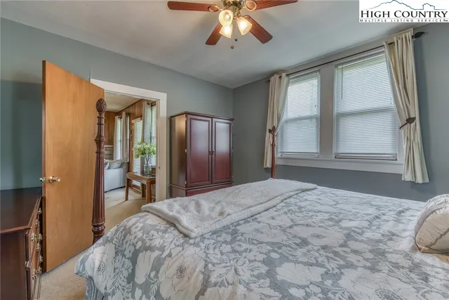 a bedroom with a large bed and a chandelier