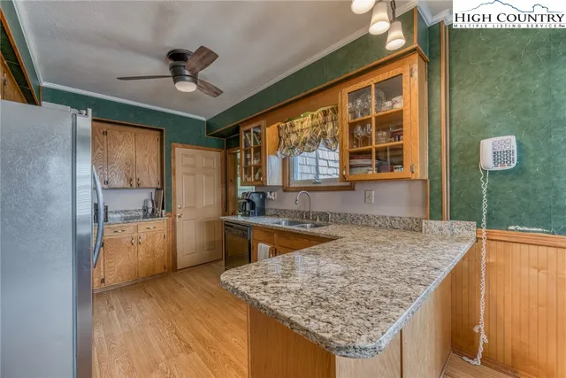 a kitchen with kitchen island granite countertop a sink and wooden cabinets