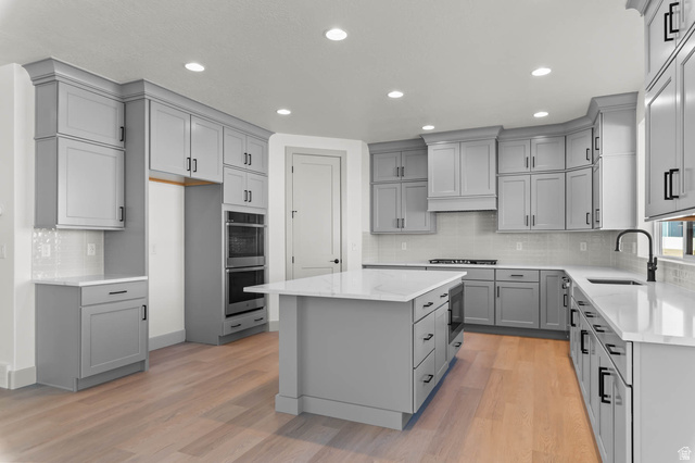 562 West Coyote Rdg Road Grantsville, UT 84029 - Photo 14 of 27 Spacious kitchen featuring light gray cabinetry, white countertops, built-in double ovens, a central island, and wood-finish flooring