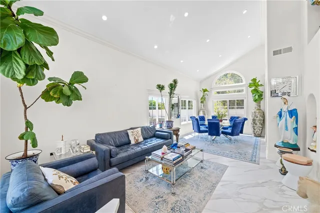 a living room with furniture plant and a chandelier