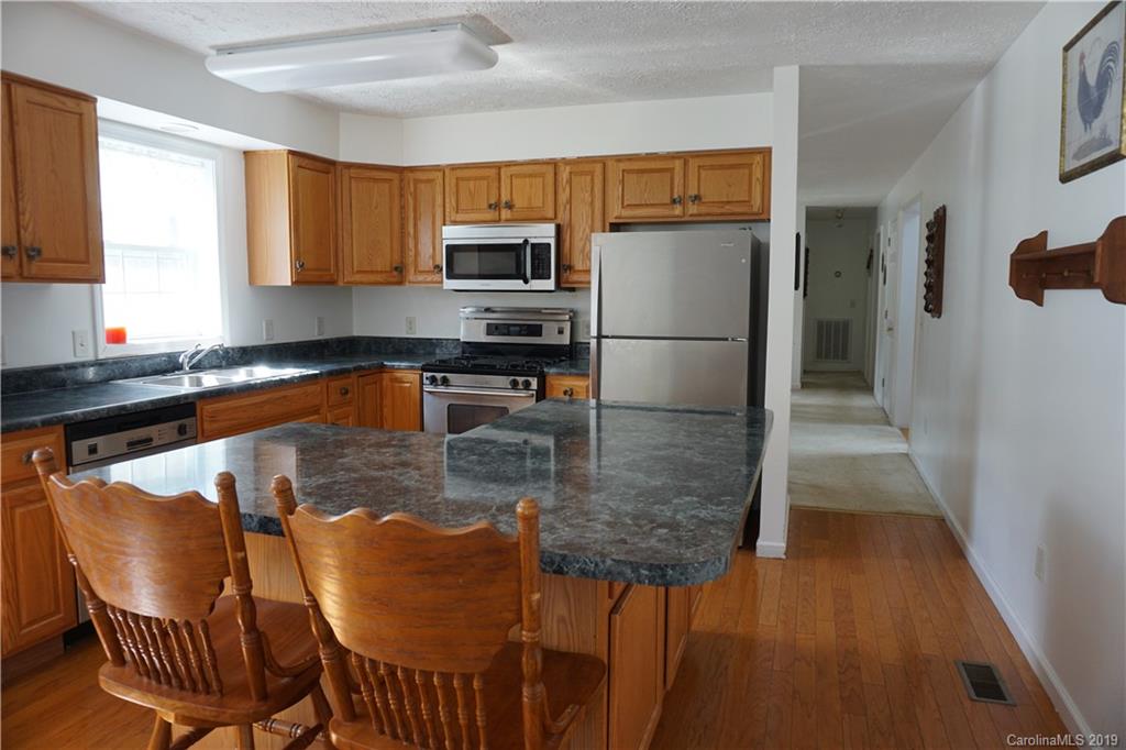 2390 Gill Jordan Road Chester, SC 29706 - Photo 7 of 44 a kitchen with stainless steel appliances granite countertop a refrigerator a stove top oven a sink dishwasher and white cabinets