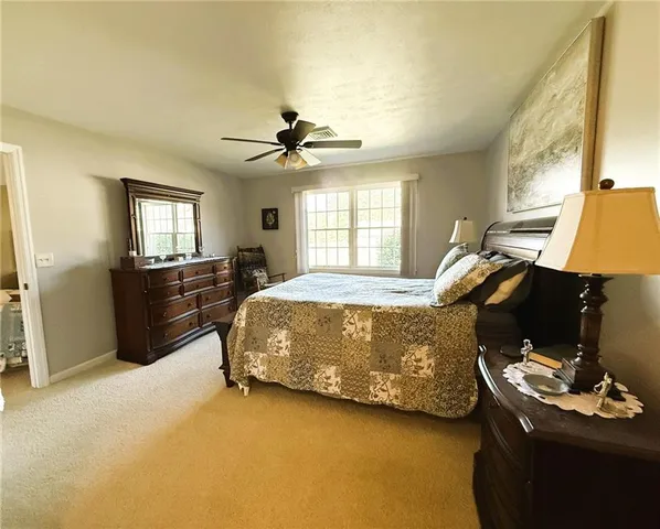 a bathroom with a toilet a sink a mirror and a window