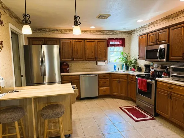 a kitchen with a sink a counter top space stainless steel appliances and cabinets