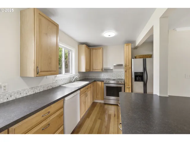 a large kitchen with cabinets and wooden floor