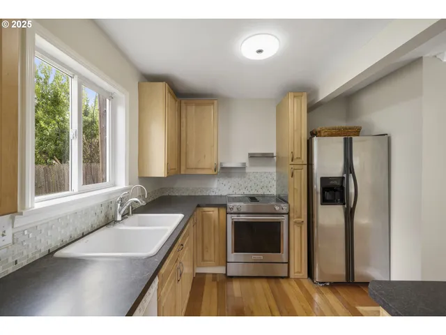 a kitchen with stainless steel appliances granite countertop a sink stove and refrigerator