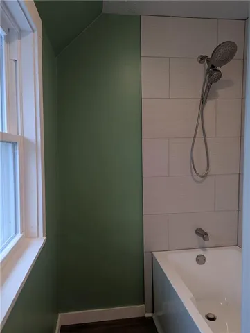 a bathroom with a bath tub with a shower