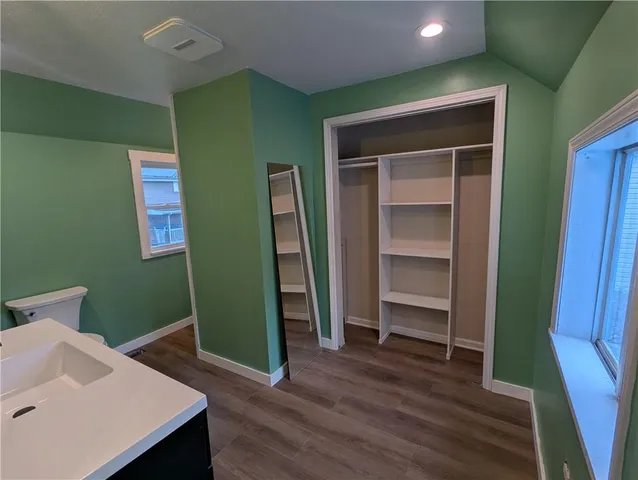 a view of a hallway to closet and wooden floor