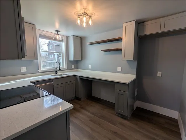 a kitchen with a sink dishwasher a stove and a refrigerator with wooden floor