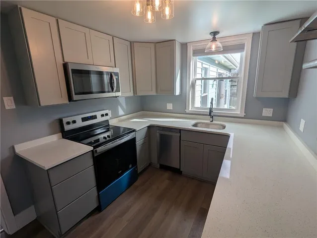 a kitchen with a sink stove a microwave and cabinets