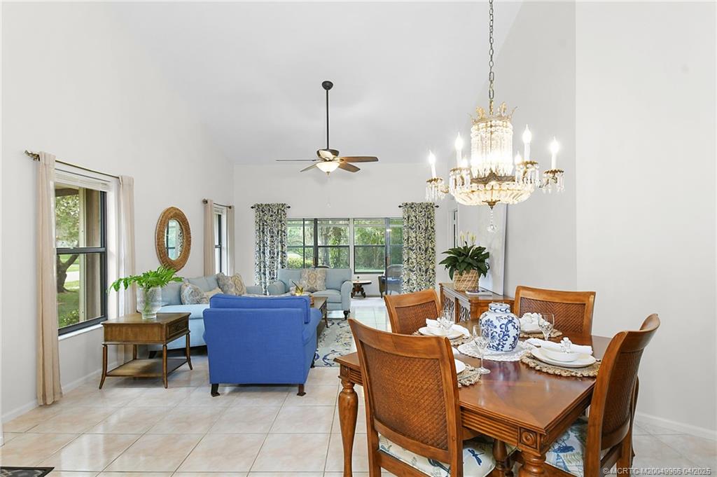 3401 Southeast Martinique Trace, Unit 101 Stuart, FL 34997 - Photo 17 of 51 a view of a dining room with furniture a chandelier and large windows