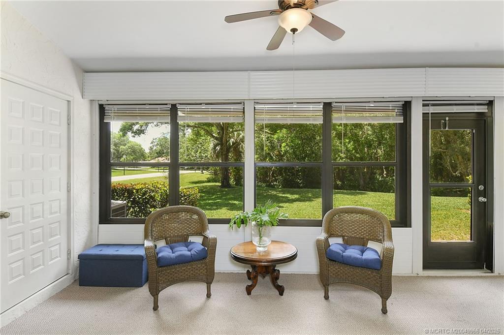 3401 Southeast Martinique Trace, Unit 101 Stuart, FL 34997 - Photo 21 of 51 a living room with patio furniture and a floor to ceiling window