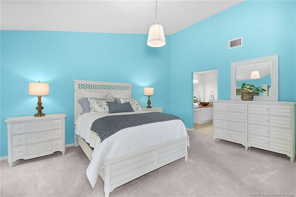 3401 Southeast Martinique Trace, Unit 101 Stuart, FL 34997 - Photo 24 of 51 a bedroom with a bed and a dresser