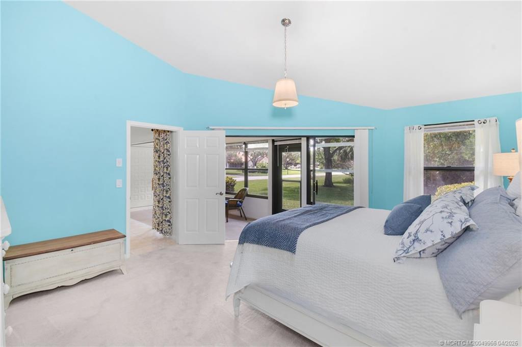 3401 Southeast Martinique Trace, Unit 101 Stuart, FL 34997 - Photo 26 of 51 a large bed sitting in a bedroom next to a window