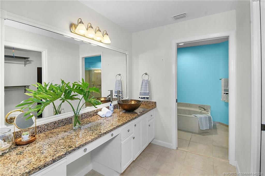 3401 Southeast Martinique Trace, Unit 101 Stuart, FL 34997 - Photo 28 of 51 a bathroom with a granite countertop sink and a mirror