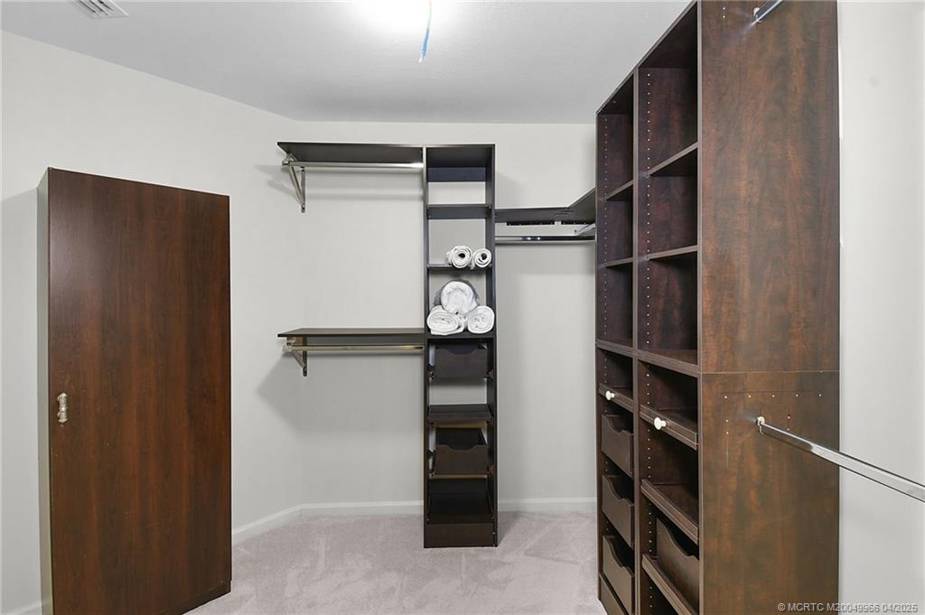 3401 Southeast Martinique Trace, Unit 101 Stuart, FL 34997 - Photo 29 of 51 a view of walk in closet with empty racks